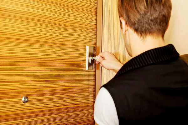 Genç adam eve dönüyor ya da evden çıkıyor.