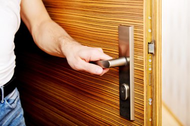 Genç adam eve dönüyor ya da evden çıkıyor.