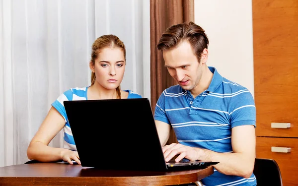 Casal jovem à procura de algo no laptop — Fotografia de Stock