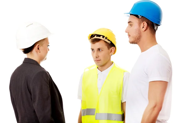 Ingenieurin im Gespräch mit zwei Bauarbeitern — Stockfoto