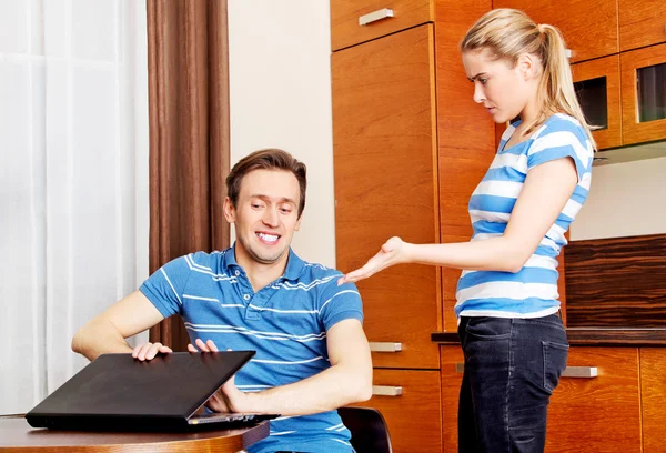 Man watching something on laptop, his wife is angry — Stock Photo, Image