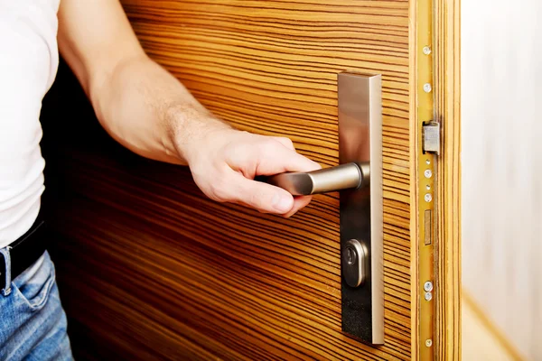 Genç adam eve dönüyor ya da evden çıkıyor.