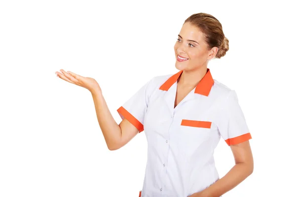 Médica ou enfermeira sorridente apontando para algo — Fotografia de Stock