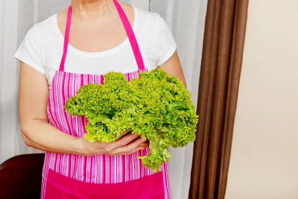 Mujer mayor sosteniendo ensalada verde —  Fotos de Stock