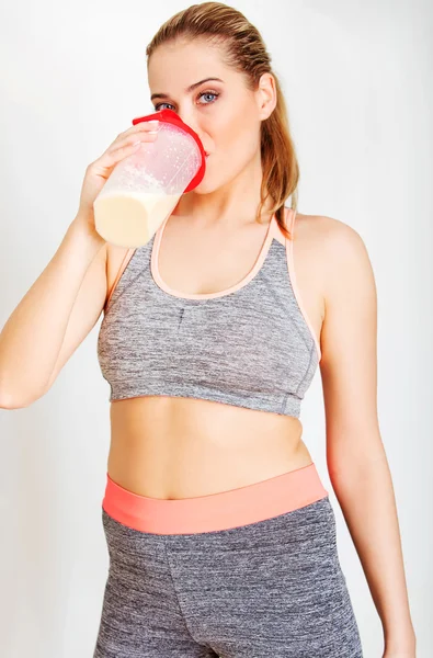 年轻的女运动员喝蛋白质奶昔 — 图库照片