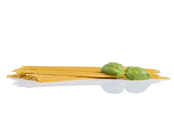 Okokt torr fettuccine pasta med grön basilika — Stockfoto