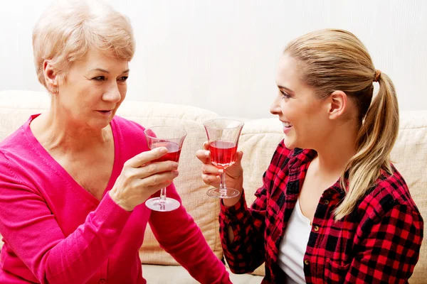 Glad äldre kvinna med dotter eller barnbarn dricker vin — Stockfoto