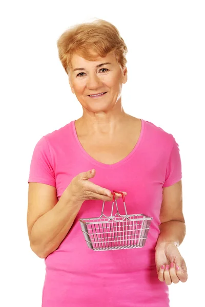 Senior smiling woman holding mini shopping basket — Stock Photo, Image