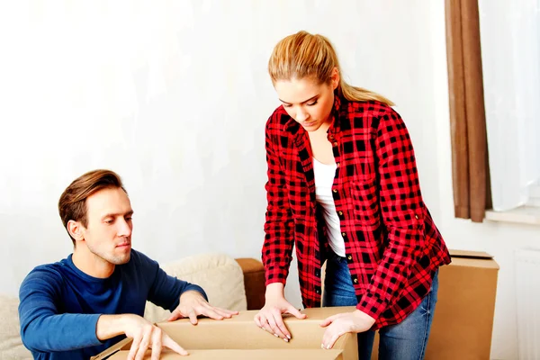 Young couple with boxes - packing or unpacking — Stock Photo, Image