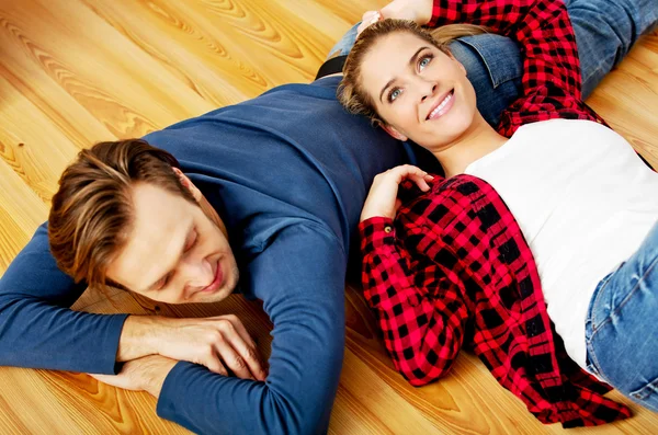 Jovem casal feliz deitado no chão — Fotografia de Stock