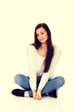 Gülümseyen genç kadın bir yere bağdaş ile oturma