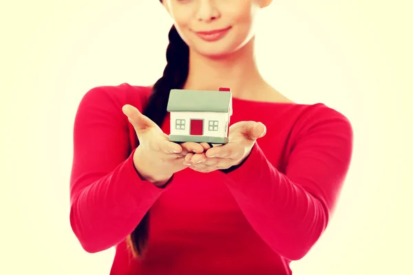 Улыбающаяся молодая женщина держит модель дома — стоковое фото