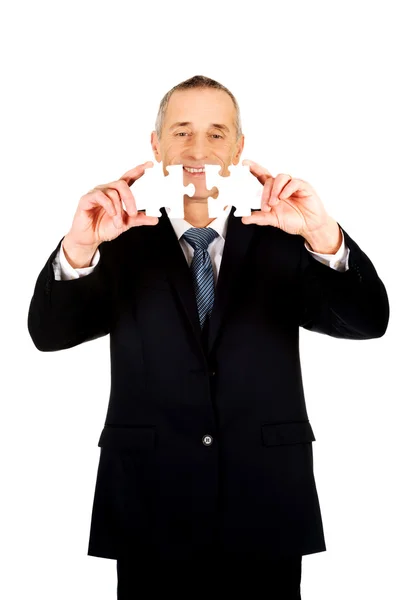 Businessman trying to connect puzzle pieces. — Stock Photo, Image