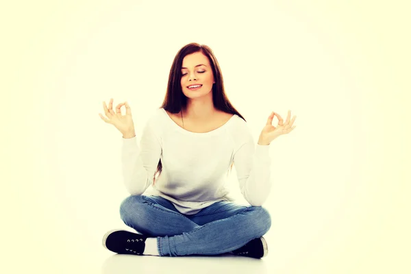 Jovem estudante mulher sentado e fazendo ioga — Fotografia de Stock