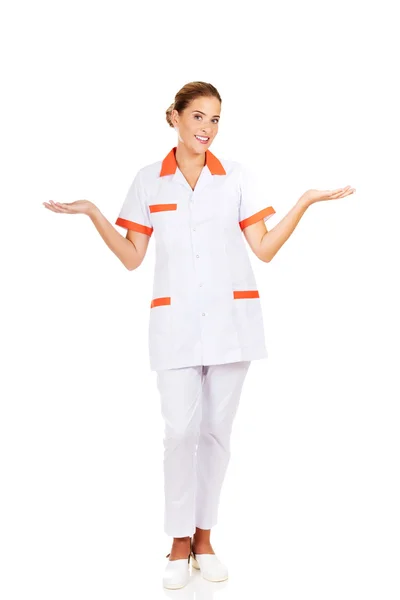 Sorridente medico femminile o infermiera che indica qualcosa — Foto Stock