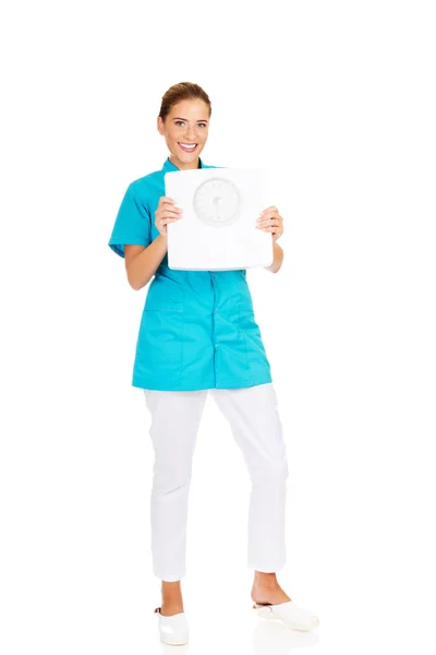 Young doctor or nurse holding weight — Stock Photo, Image