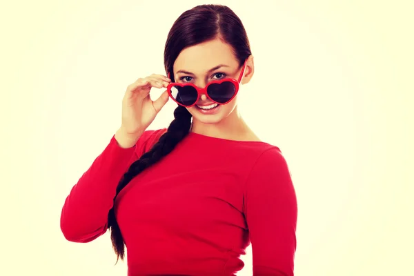 Glückliche brünette Frau mit Sonnenbrille in Herzform — Stockfoto