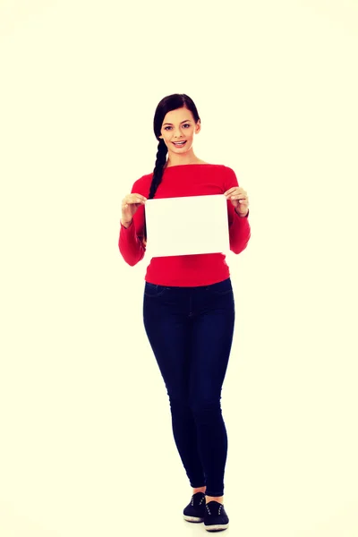 Sonríe joven mujer sosteniendo banner blanco en blanco — Foto de Stock