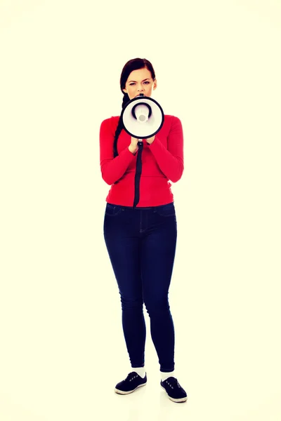 Mladá naštvaná žena křičí přes megafon — Stock fotografie
