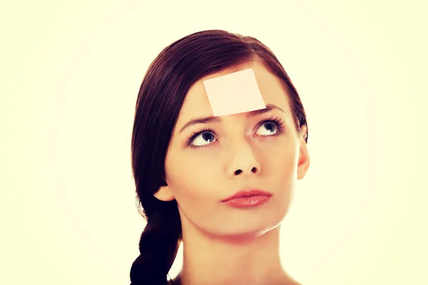 Young woman with sticky notes on forehead — Stock Photo, Image