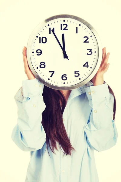 Rano kobieta w wielkim koszula chowając się za zegar. — Zdjęcie stockowe