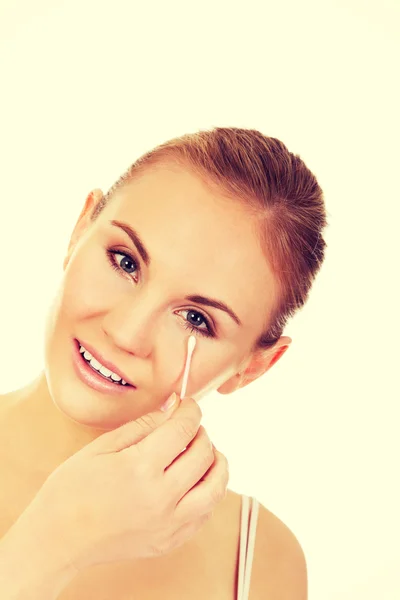 Jonge vrouw verwijderen van oog make-up met wattenstaafje — Stockfoto