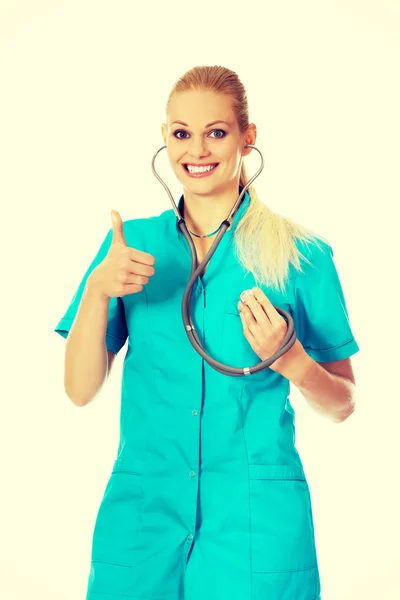 Médico o enfermera sonriente con estetoscopio que muestra el pulgar hacia arriba — Foto de Stock