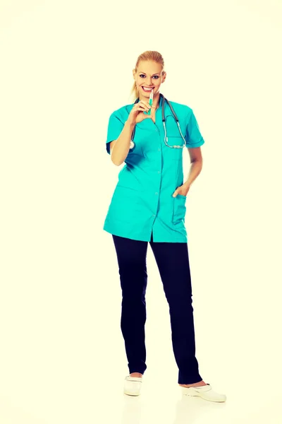 Улыбающаяся женщина-врач или медсестра со стетоскопом, держащая шприц — стоковое фото