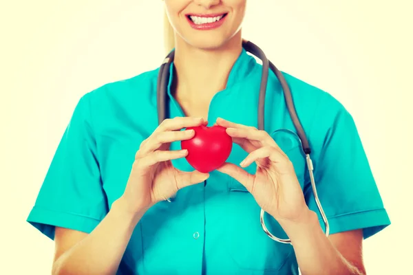 Smiling female doctor with stethoscope holding heart model — Stock Photo, Image