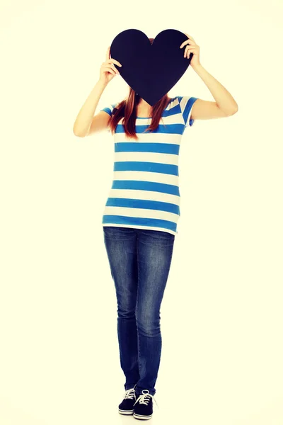 Teenage woman covering her face with paper heart — Stock Photo, Image