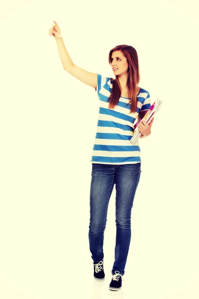 Teenage glad kvinna håller läroböcker och pekar för något — Stockfoto