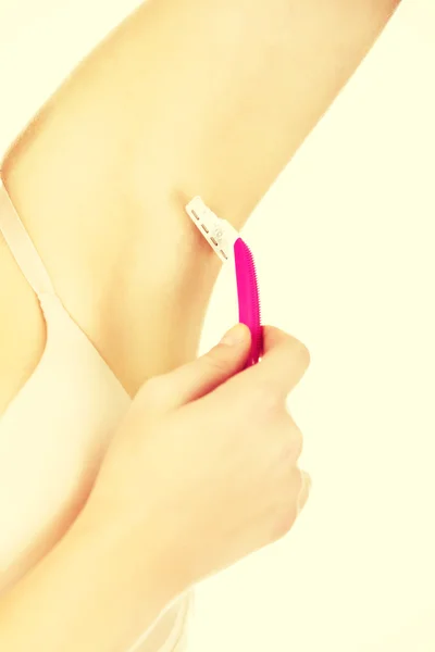 Young woman shaving armpit pink razor — Stock Photo, Image