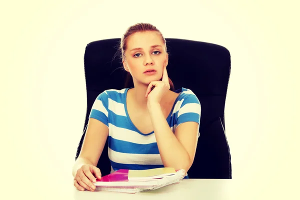 Tonåriga kvinna sitter bakom skrivbordet och tänkande — Stockfoto