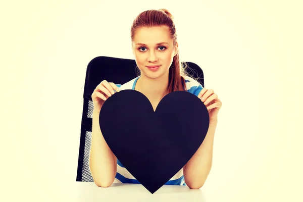 Teenage woman holding black paper heart — Stock Photo, Image