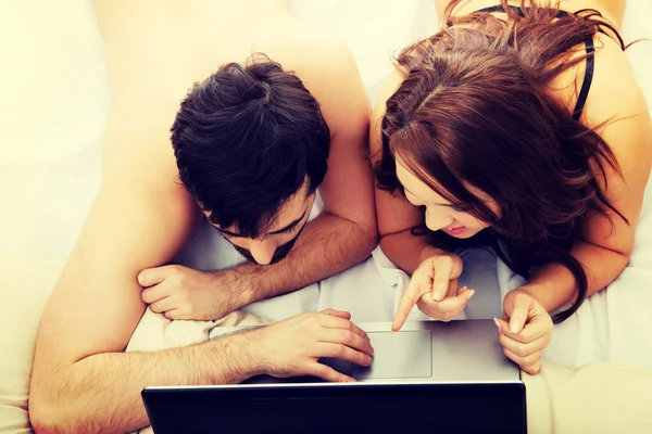 Pareja feliz en el ordenador portátil en el dormitorio . —  Fotos de Stock