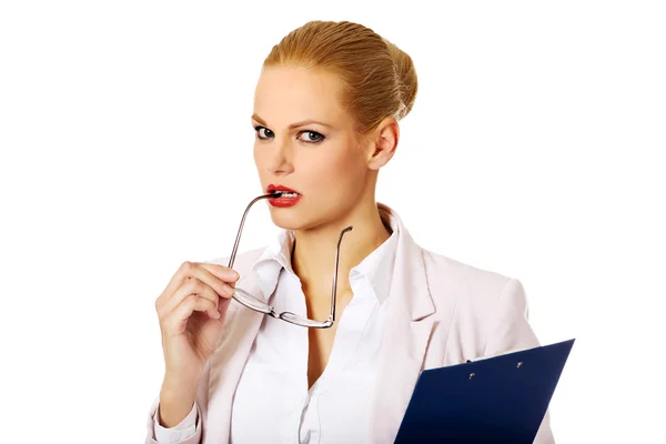 Pensive mulher de negócios segurando uma prancheta e óculos — Fotografia de Stock