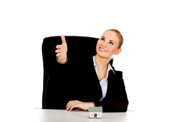 Affärskvinna med en öppen hand redo för handslag och hus modell på skrivbordet — Stockfoto