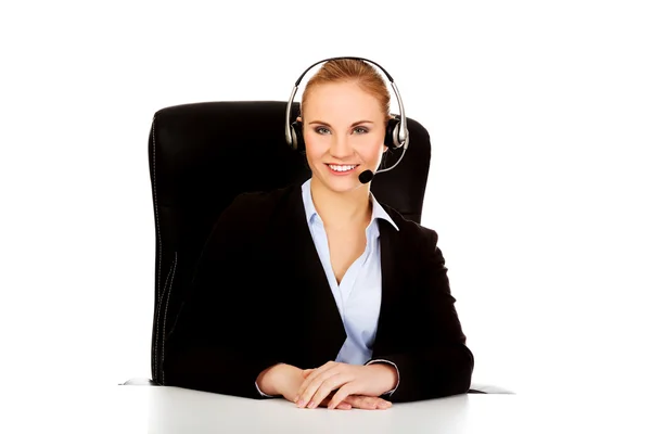 Smiling phone operator in headphones sitting  behind the desk — Stock Photo, Image