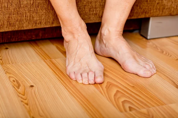 Voeten van een oude vrouw op de verdieping — Stockfoto