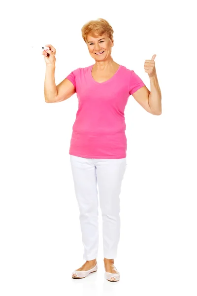 Senior vrouw toont thermometer en gebaren Ok — Stockfoto