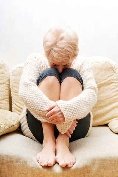 Mulher idosa com depressão sentada no sofá — Fotografia de Stock