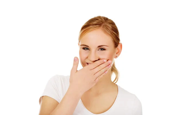 Young woman giggles covering her mouth with hand Stock Image