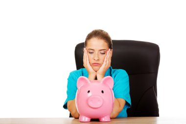 Genç kadın doktor ya da hemşire kumbara tutuyor.