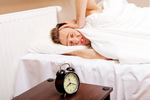 Homem a tentar dormir, quando o despertador toca — Fotografia de Stock