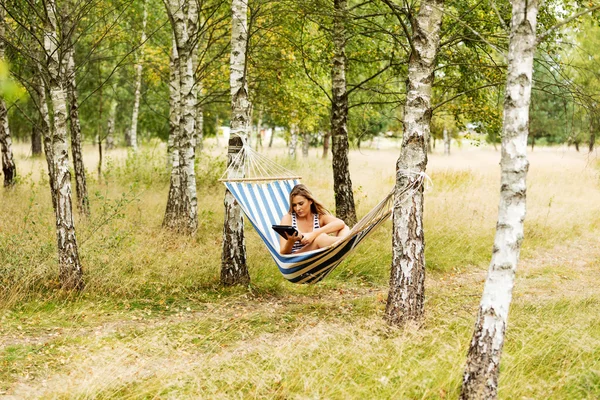 Young woman with tablet on the hammock — Stock Photo, Image