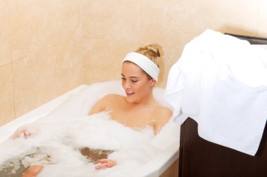 Genç bayan banyoda dinleniyor.