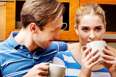 Genç çift mutfakta çay ya da kahve içiyor.