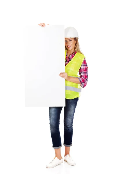 Jonge lachende vrouwelijke bouwer bedrijf leeg banner — Stockfoto