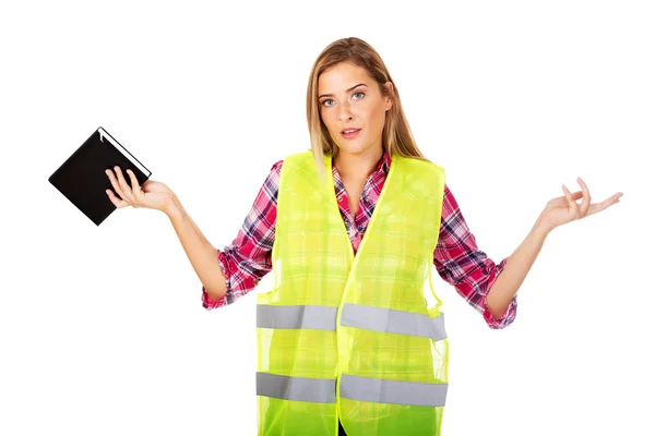 Vrouwelijke bouwer in een helm en een vest met een notebook — Stockfoto