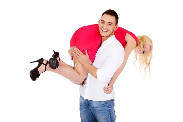 Молодой человек носит свою девушку на плече — стоковое фото